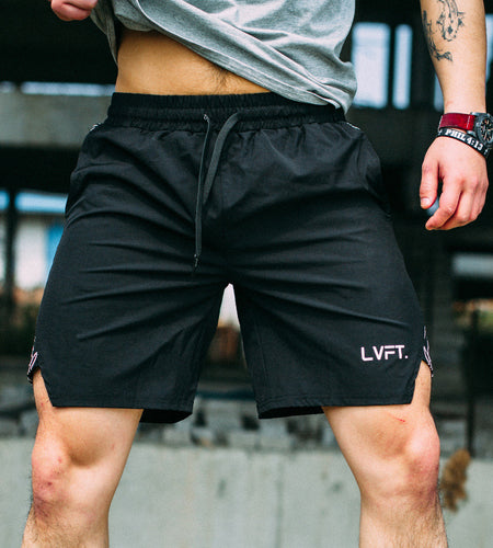 Person wearing black shorts with 'LVFT' branding in an urban setting