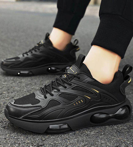 Black sneakers being worn on a dark surface