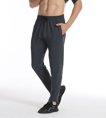 Person wearing dark gray athletic pants on a white background