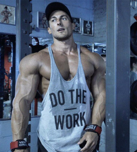 Muscular man in a gym wearing a tank top with 'Do The Work' text