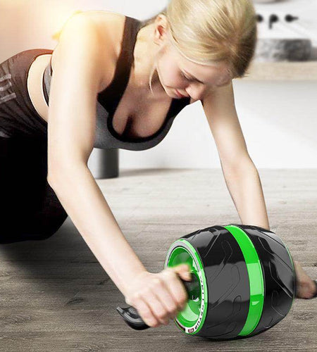 Woman using an ab roller on a wooden floor