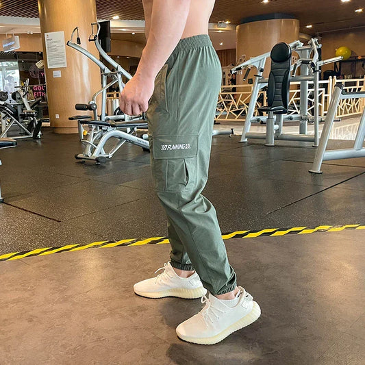 Person wearing green cargo pants and white sneakers in a gym setting