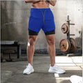 Person wearing blue athletic shorts with a black inner layer in a gym setting