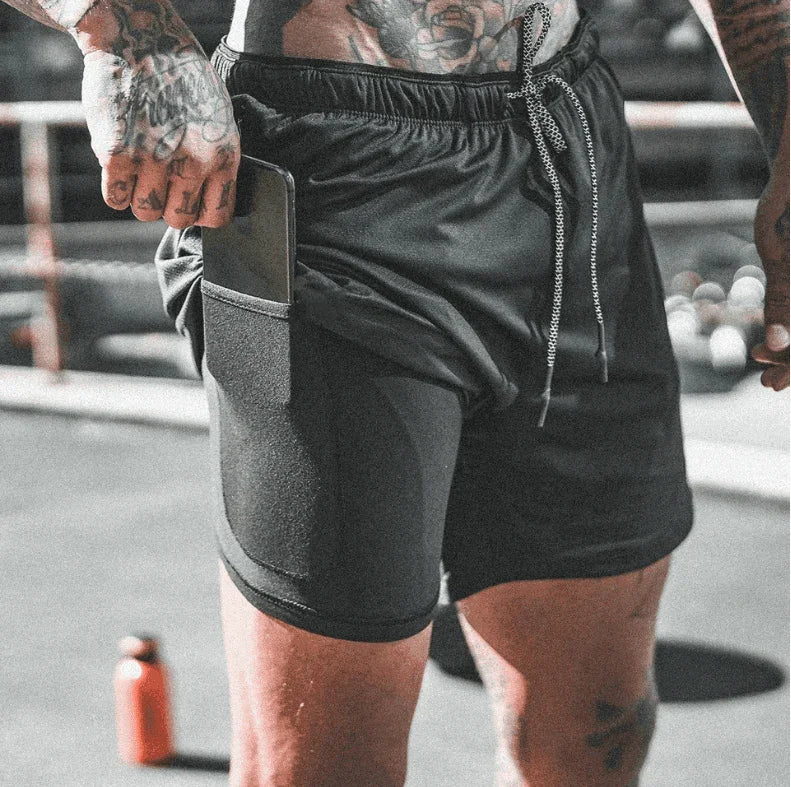 Person wearing black athletic shorts with a pocket on a blurred background