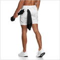 Person wearing white athletic shorts with a black towel over one shoulder on a white background