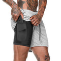 Person wearing a black and gray athletic shorts with a white background