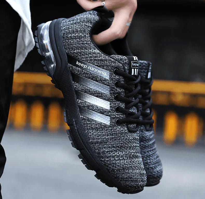 Black and gray athletic shoe with 'keep running' text on a blurred background