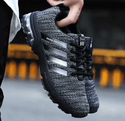 Black and gray athletic shoe with 'keep running' text on a blurred background