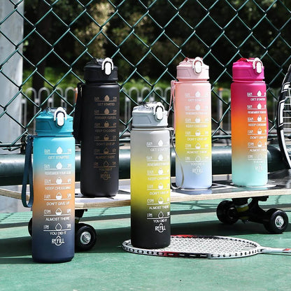 Set of colorful water bottles with gradient designs on a sports court.