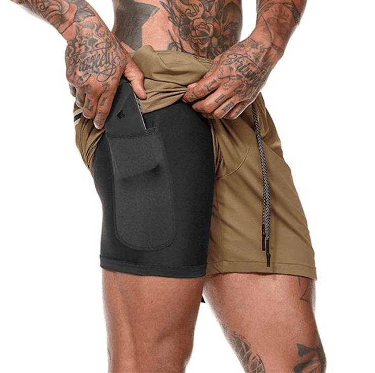 Person wearing a black and brown athletic shorts with a white background