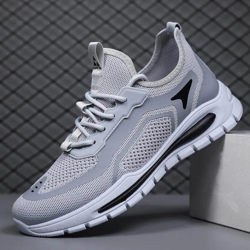 Gray athletic shoe with white sole on a dark grid background