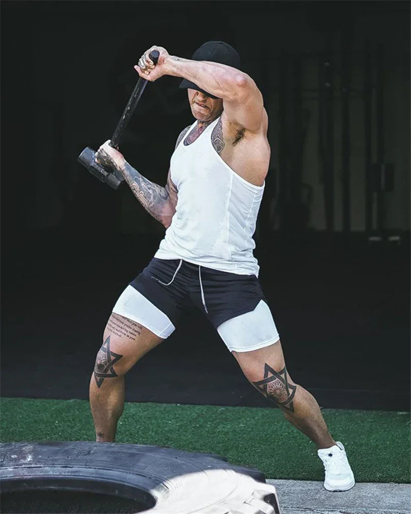 Man in athletic wear performing a workout with a tire on a dark background