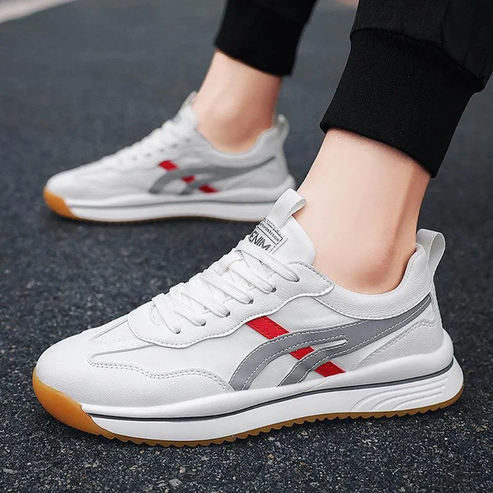 White sneakers with red and gray accents worn on a dark surface