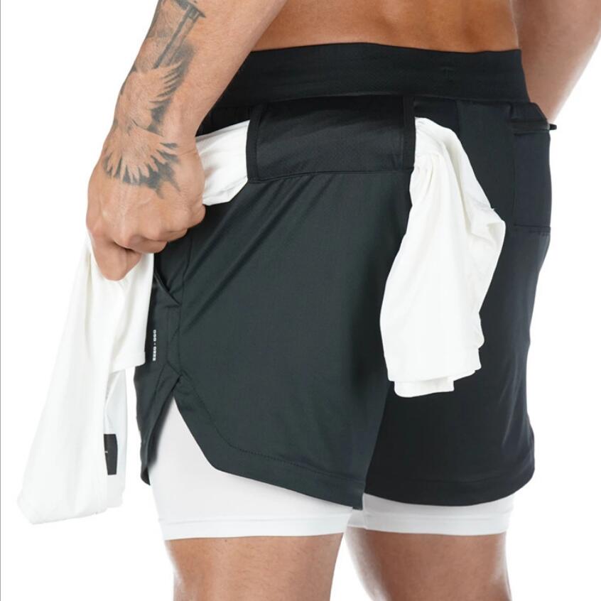 Person wearing black athletic shorts with white inner lining on a white background