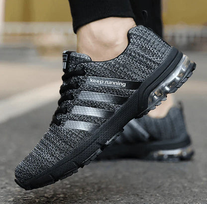 Gray and black athletic shoe with 'Keep running' text on a blurred background