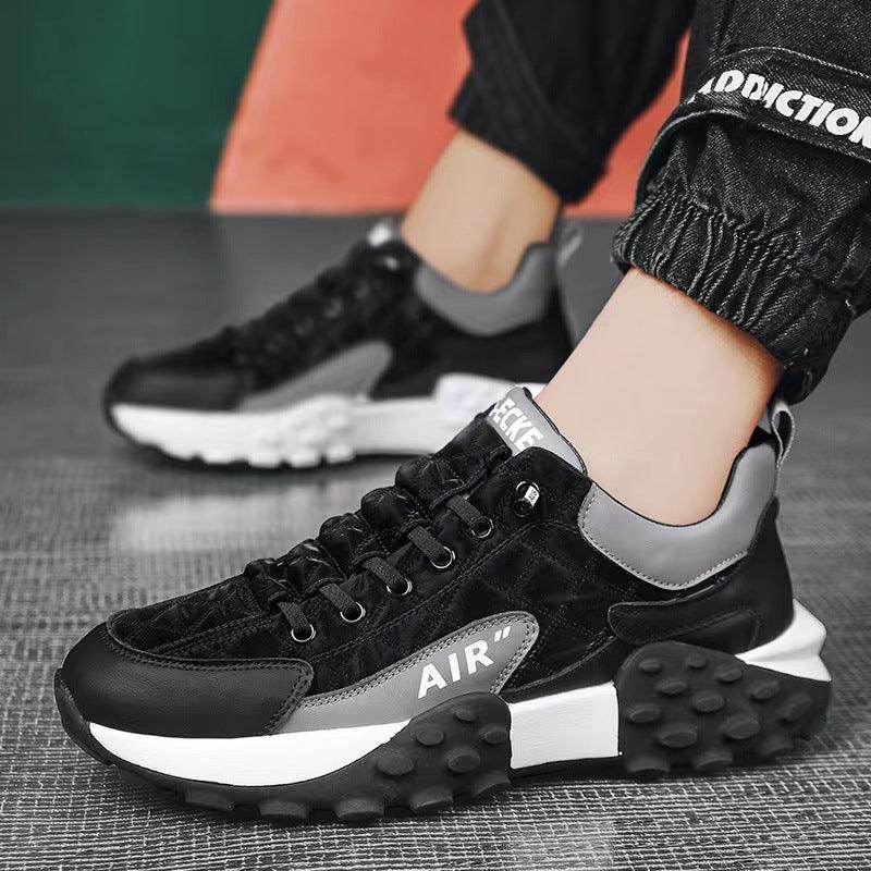 Black and gray sneakers with 'AIR' branding on a textured surface.