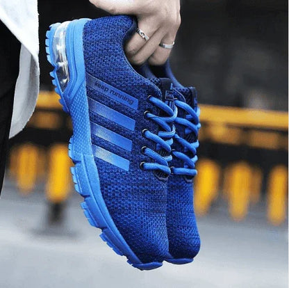 Blue running shoe held by a hand with blurred background