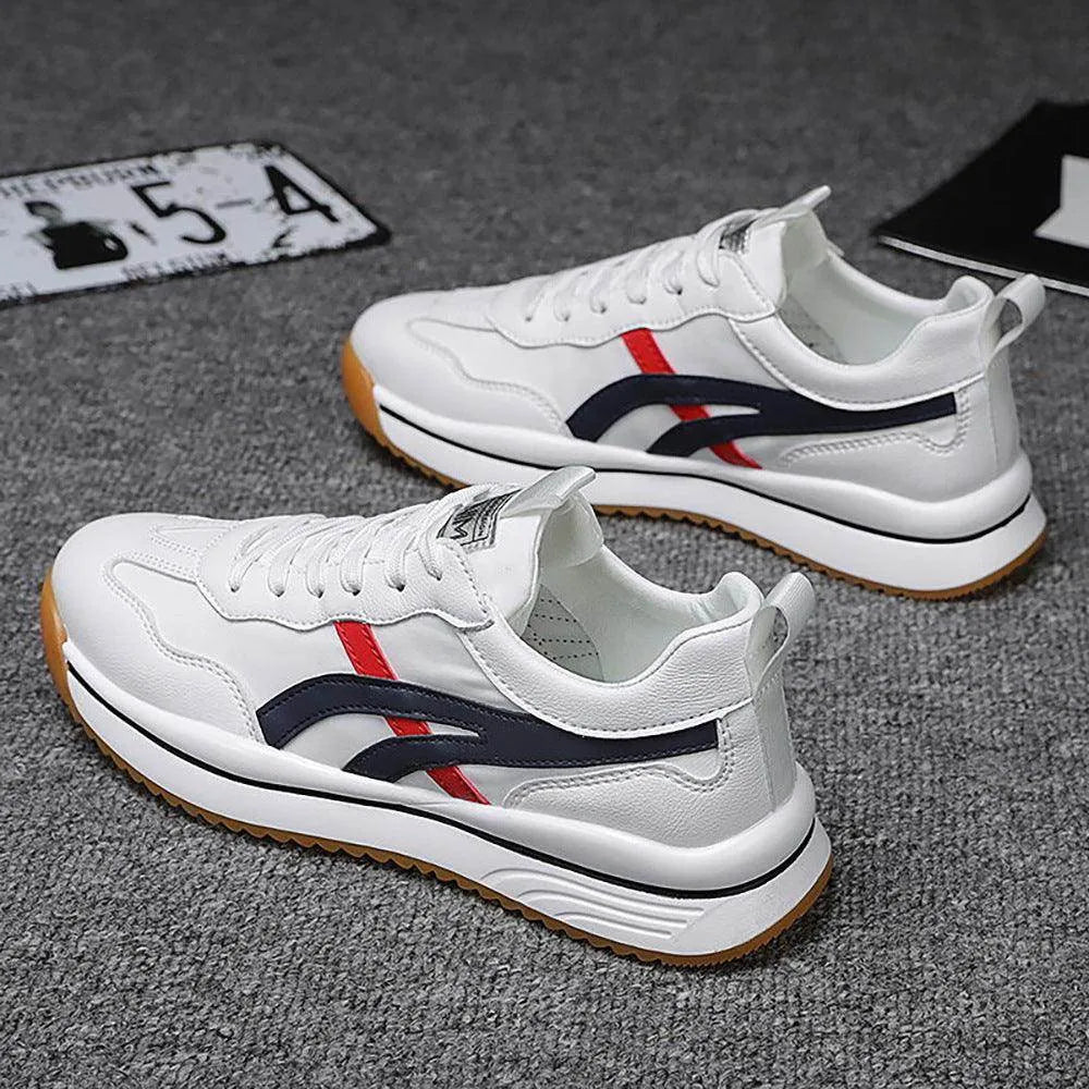 White sneakers with red and blue accents on a gray surface