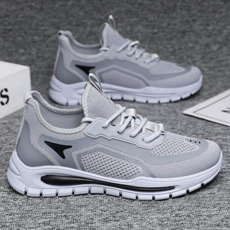 Gray running shoes with white soles on a gray surface