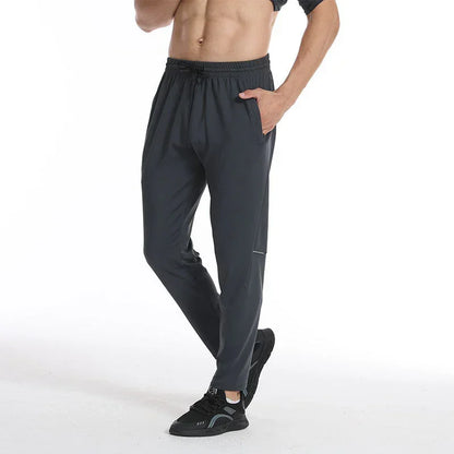 Person wearing dark gray athletic pants on a white background