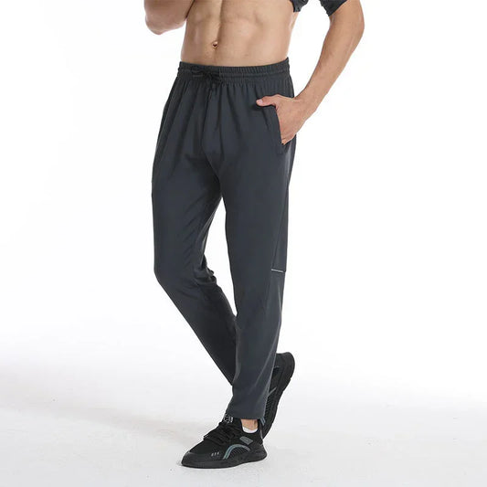 Person wearing dark gray athletic pants on a white background
