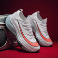 White sneakers with orange accents on a red surface with a retro radio in the background