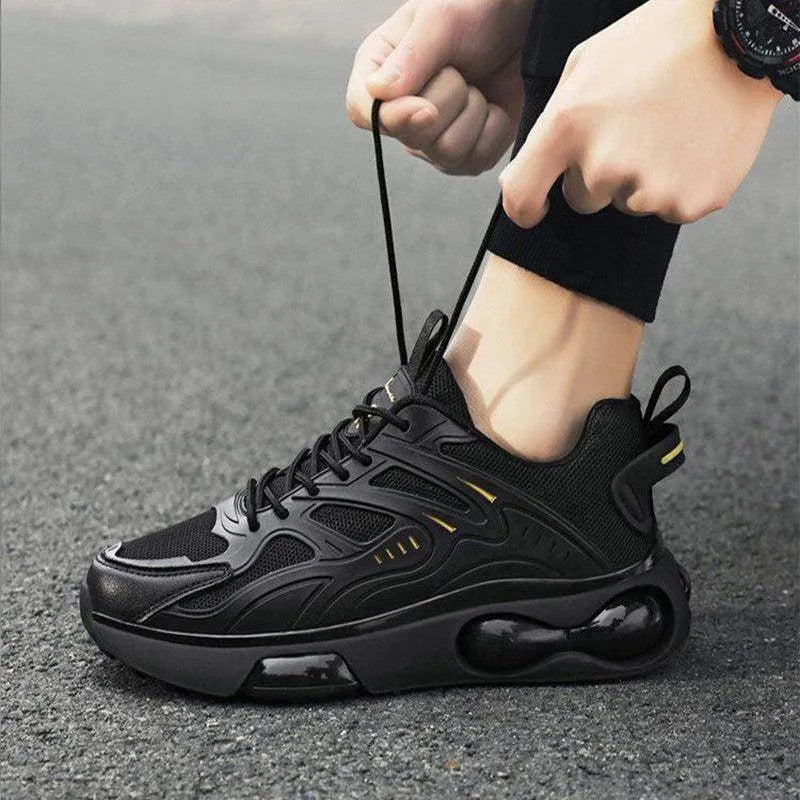 Person wearing a black sneaker with a unique sole design on a gray pavement background