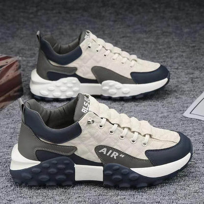 Pair of gray and navy sneakers on a textured surface