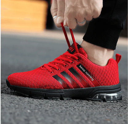 Red athletic shoe with black stripes being worn on a blurred outdoor background