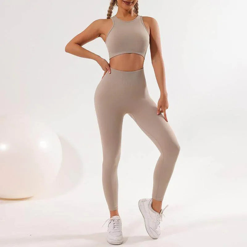 Woman wearing a beige athletic outfit with leggings and sports bra on a white background