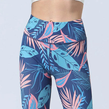 Tropical leaf patterned leggings on a plain background