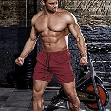 Muscular man in red shorts standing in a gym setting