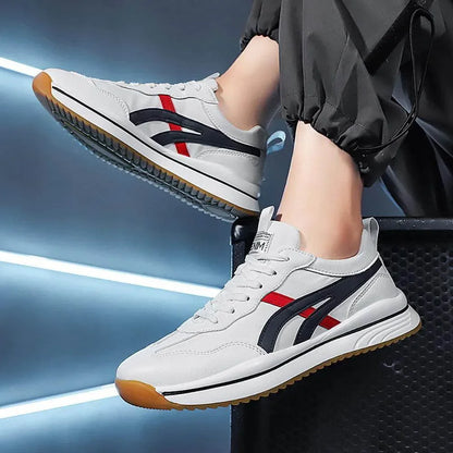 White sneakers with red and black accents worn by a person on a blurred background