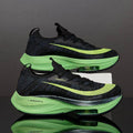 Black and green running shoes with 'Zoom X' branding on a reflective surface.