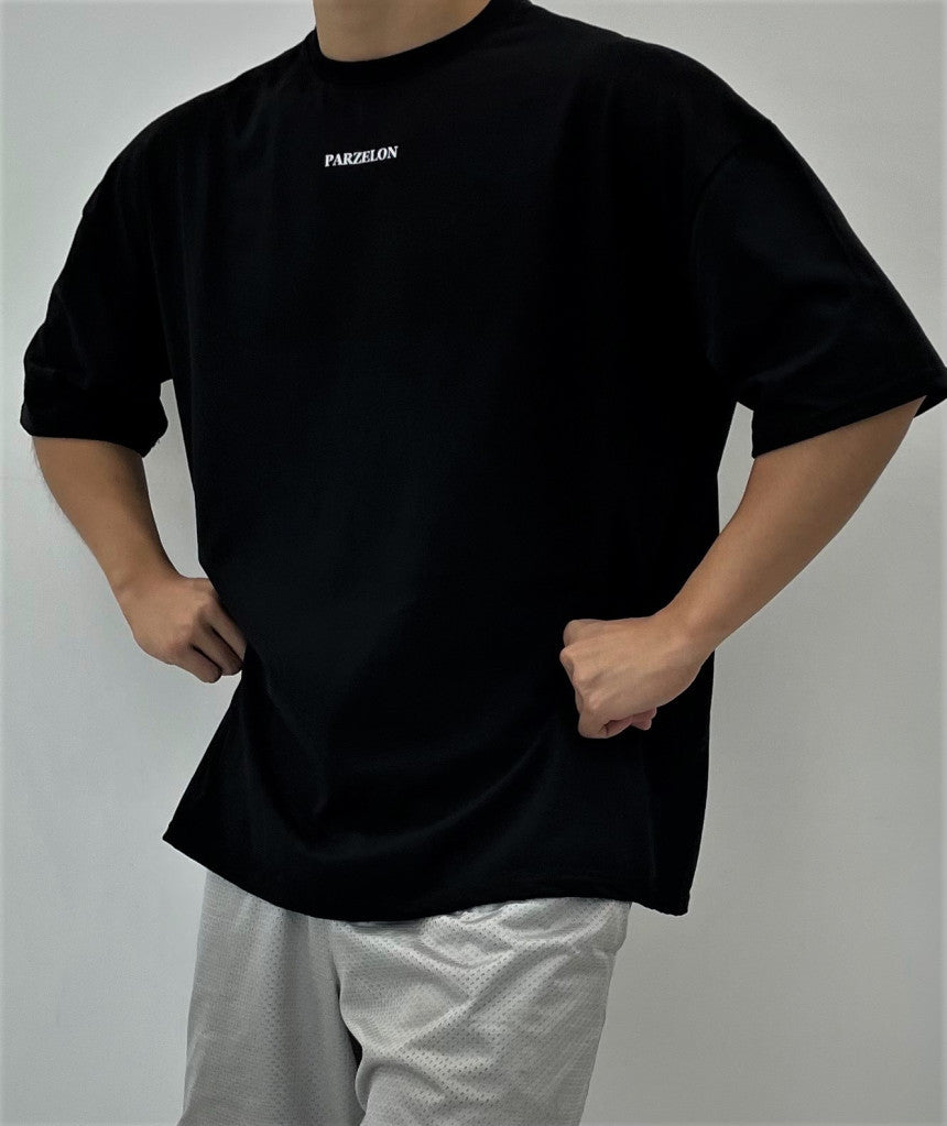 Person wearing a black t-shirt with 'PARZELON' branding on a plain background