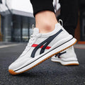 White sneakers with red and black accents on a blurred street background