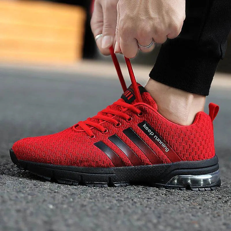 Red running shoe with black stripes being worn on a blurred background