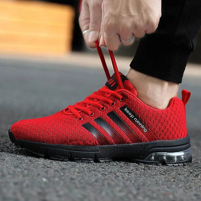 Red running shoe with black stripes being worn on a blurred background
