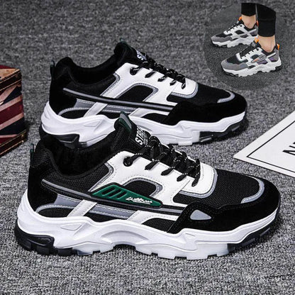 Black and white sneakers with green accents on a gray surface