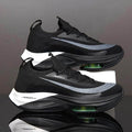 Black and gray athletic shoes with green sole on a reflective surface.