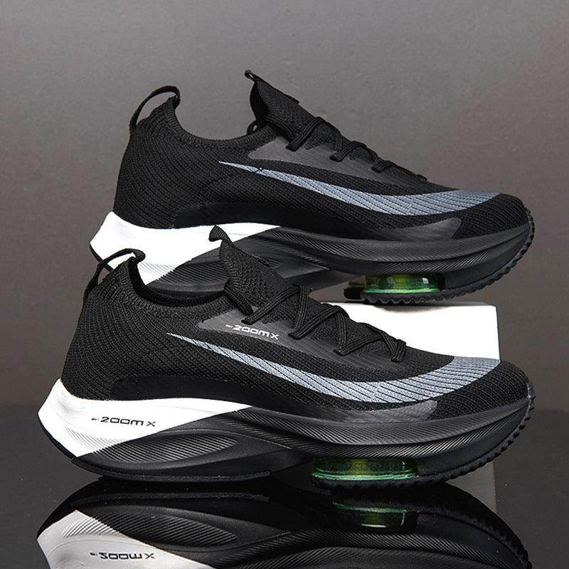 Black and gray athletic shoes with green sole on a reflective surface.