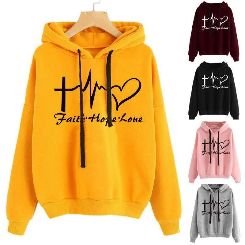 Yellow hoodie with 'Faith Hope Love' design on a hanger, surrounded by other color variations.