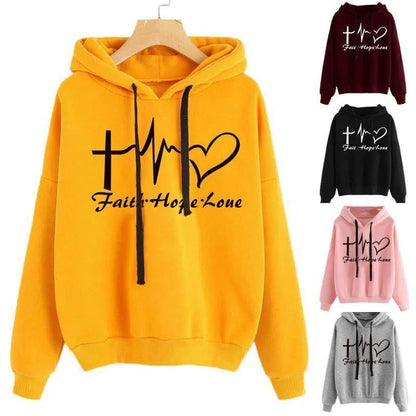 Yellow hoodie with 'Faith Hope Love' design on a hanger, surrounded by other color variations.