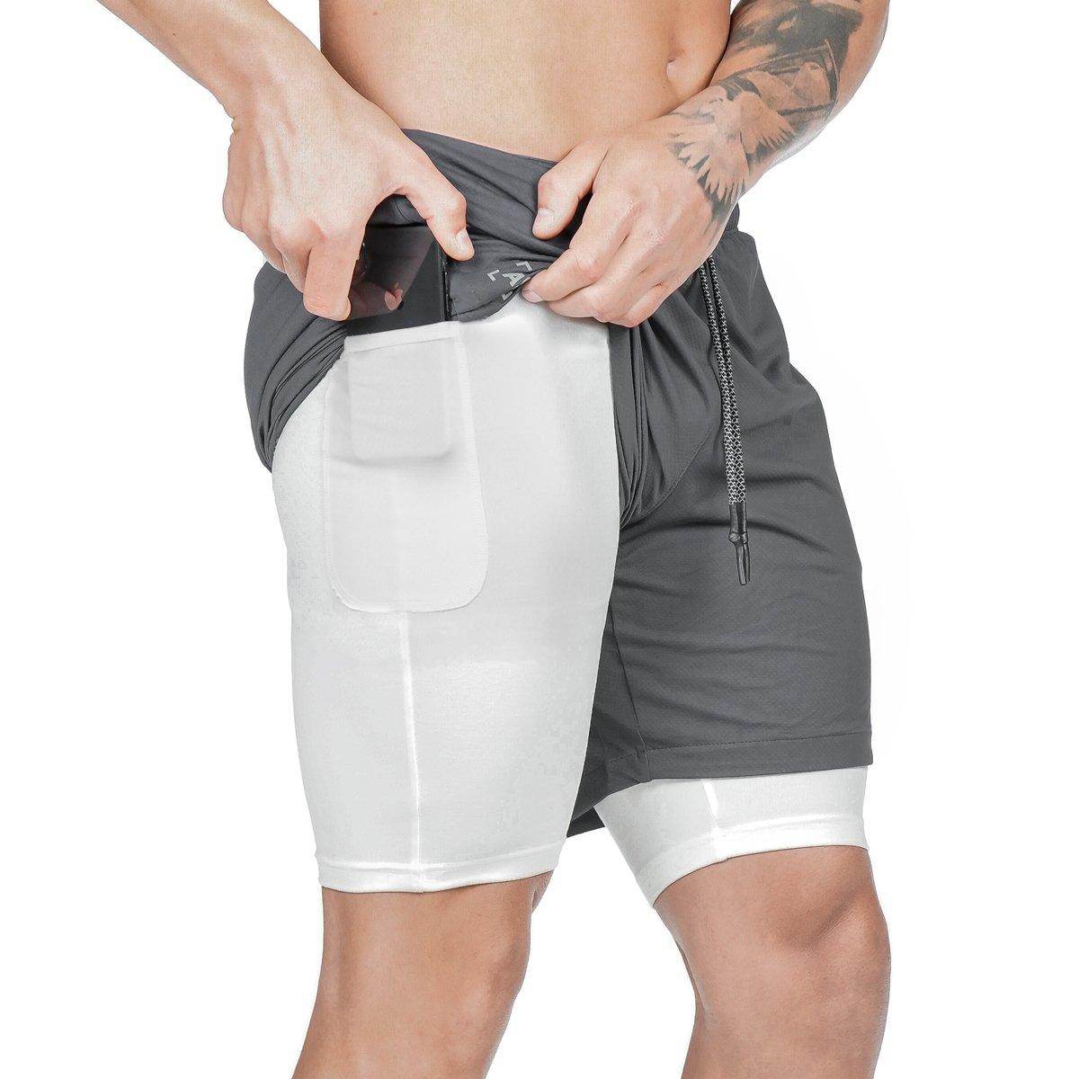 Person wearing a gray and white athletic shorts with a white background