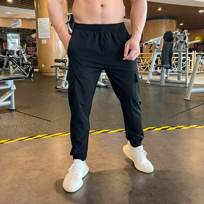 Person wearing black pants and white sneakers in a gym setting