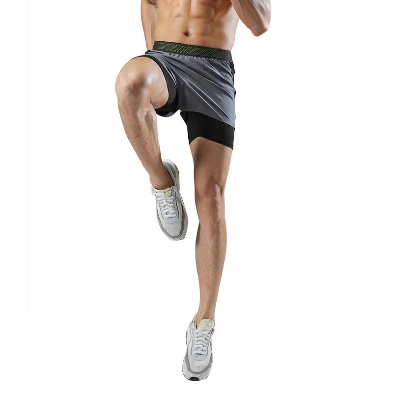Person wearing gray athletic shorts and white sneakers on a white background