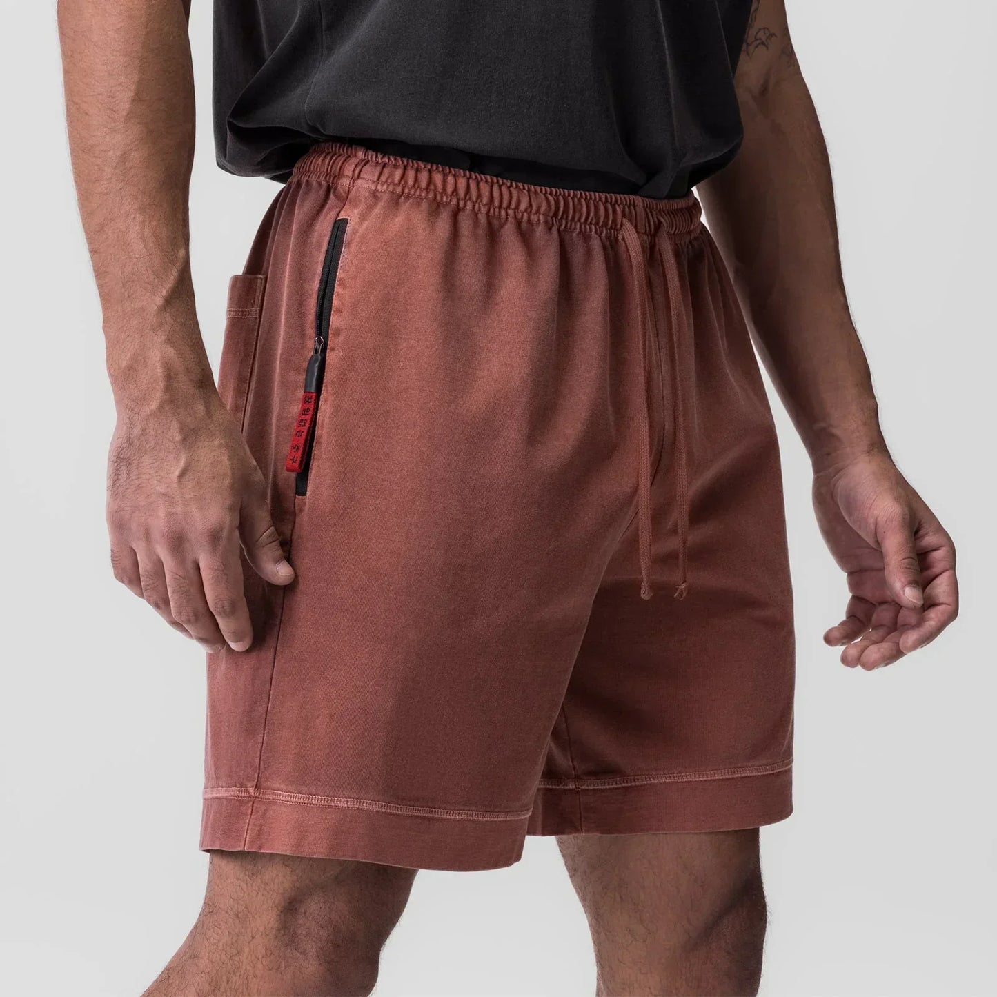 Brown shorts worn by a person on a light gray background