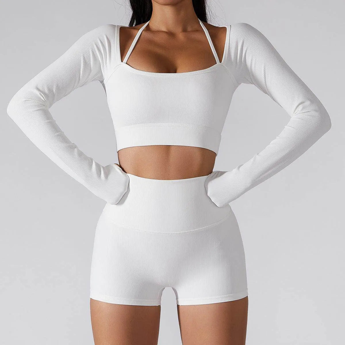 Person wearing a white long-sleeve crop top and shorts set on a light gray background