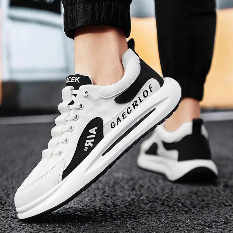 White sneakers with black accents worn by a person on a blurred background