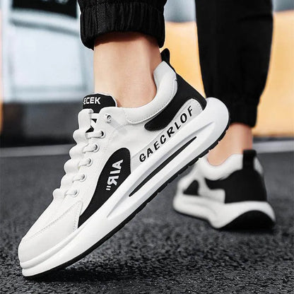 White sneakers with black accents worn by a person on a blurred background